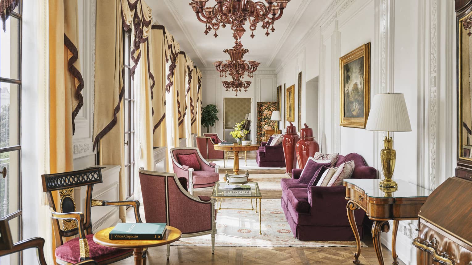 Grand hallway with chandeliers and plum-coloured sofas and chairs, Royal Suite at Four Seasons Hotel Florence