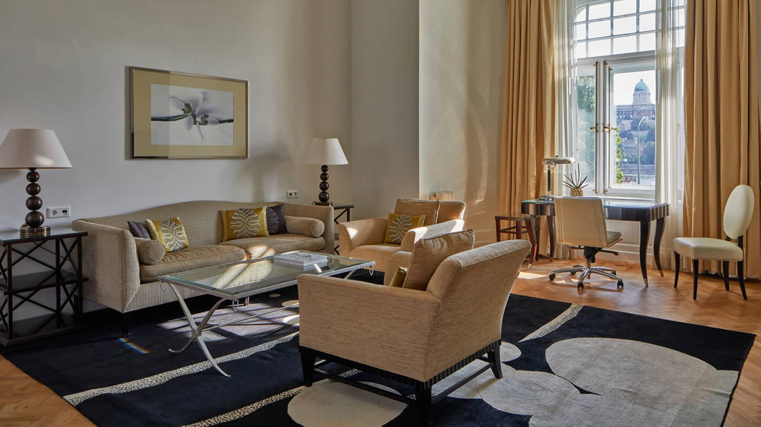 A sitting area with coffee table, sofa, chairs and desk with chair.