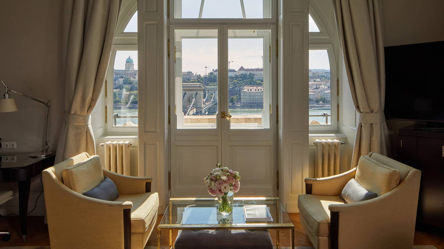 A sitting area with two chairs and a small table near windows.