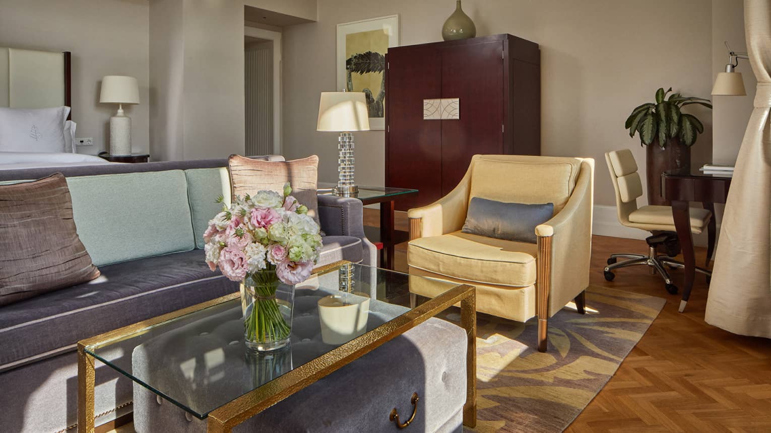 A sitting area with a chair, coffee table and sofa.