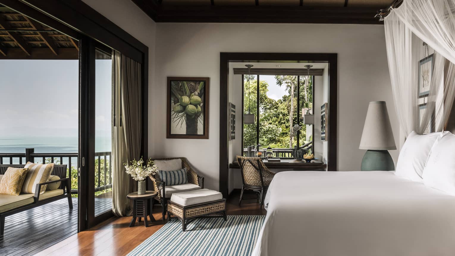 Deluxe One-Bedroom Pool Villa bedroom with bed, wicker armchair, open-air wall to patio