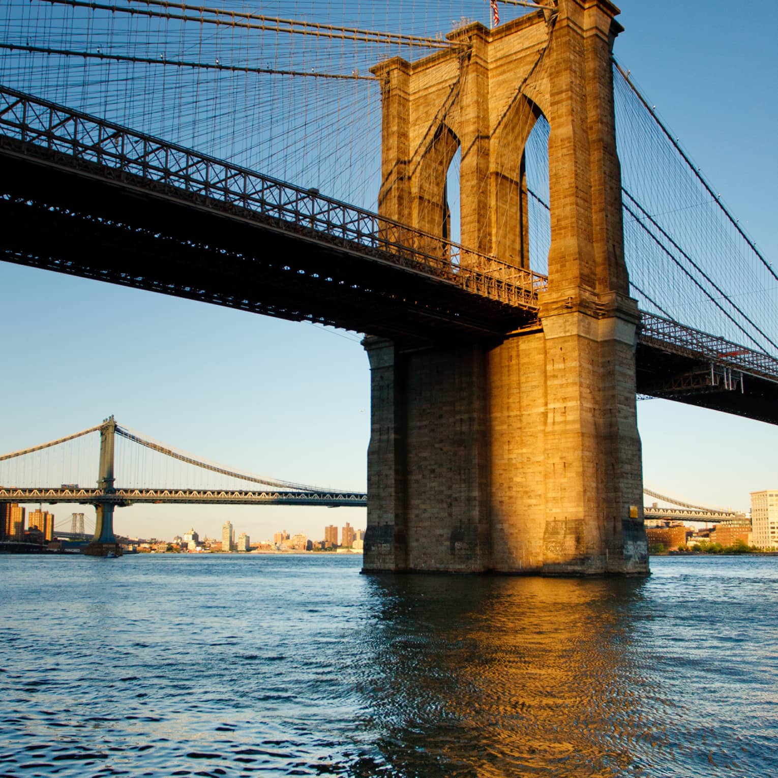 The Brooklyn Bridge at sunset on the water 