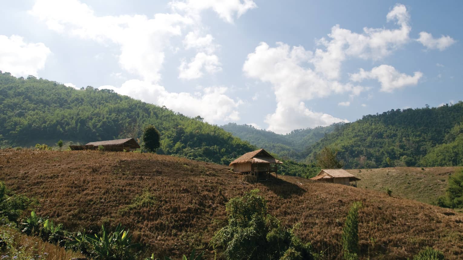 The rolling hills of Wang Lao Trail, blue sky and fluffy white clouds
