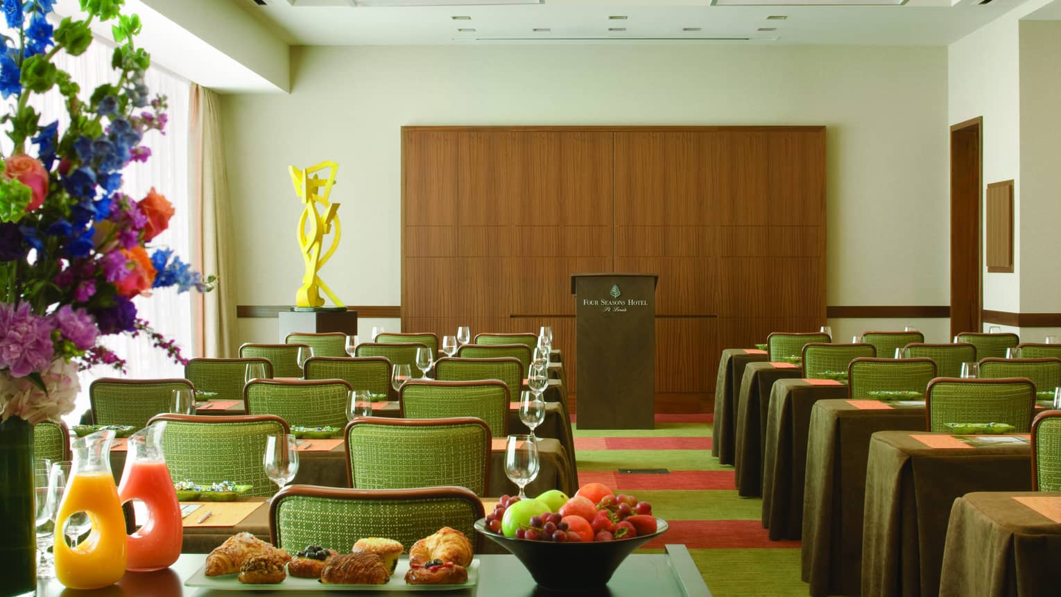 Gateway Meeting Room, rows of small meeting tables face podium, breakfast station