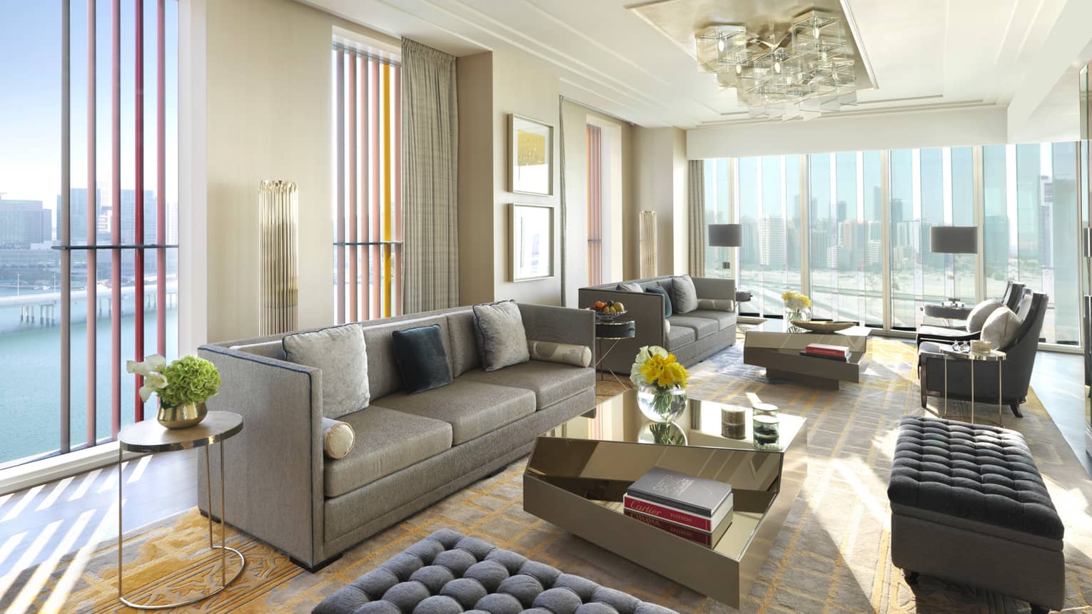 Presidential Suite with grey sofas and ottomans, floor-to-ceiling corner windows with sunny Gulf views