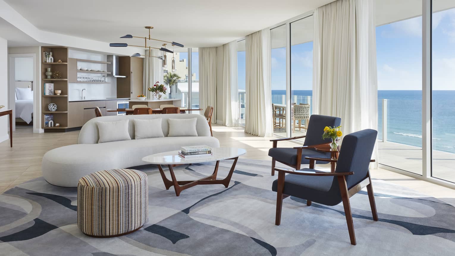 Living room and dining room with wall of windows, ocean view