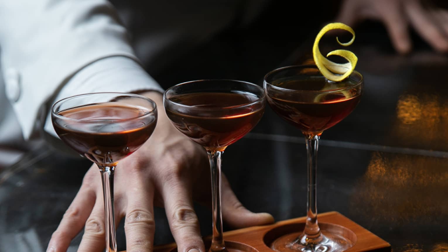 Row of three cocktails ? Classic Manhattan, De La Louisiane and Vieux Carr� ? in wooden stand