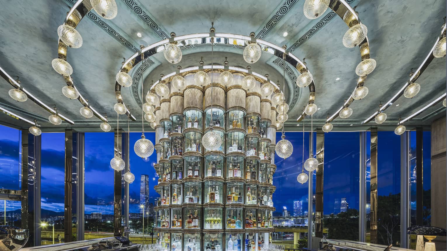 Crystal pillar bar shelves behind a bar counter with city view