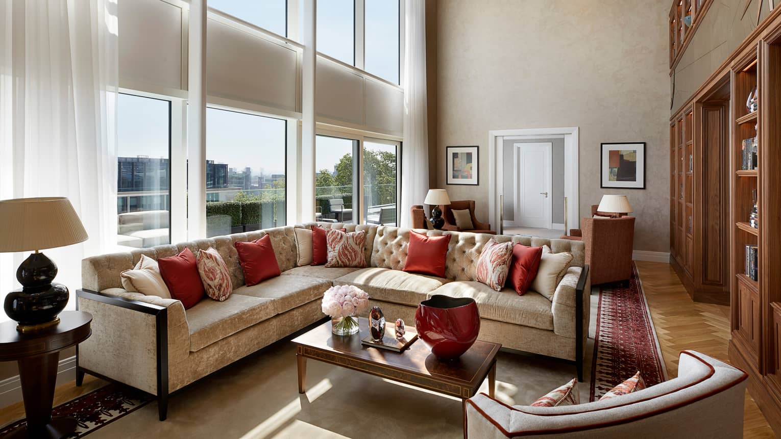 Large L-shaped velvet sofa, living room under sunny, two-storey floor-to-ceiling window