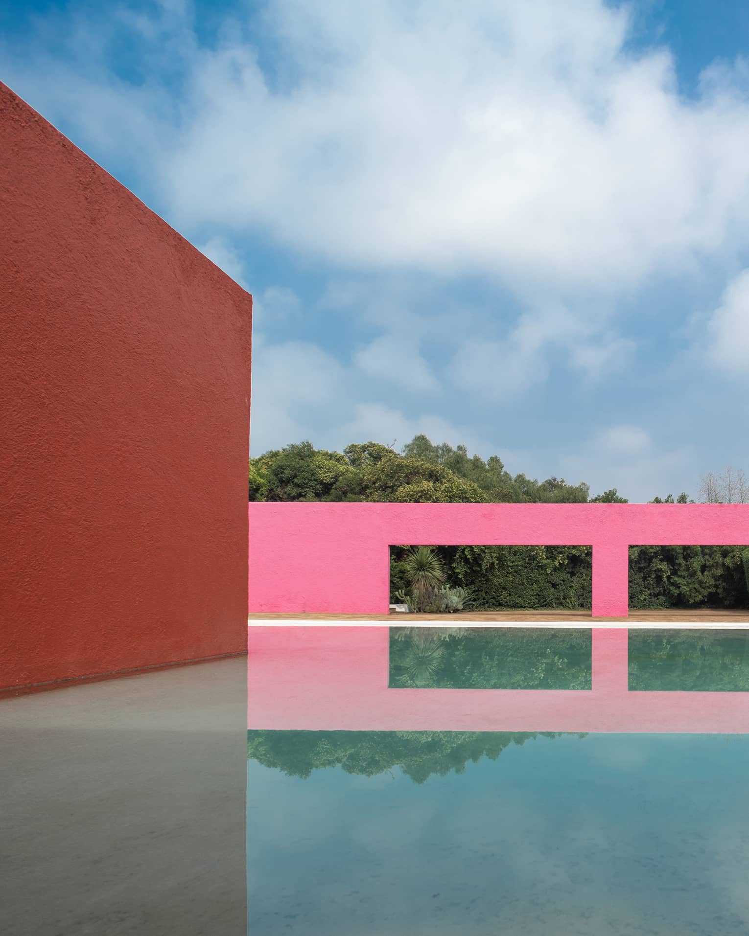 A pink building next to water outside.