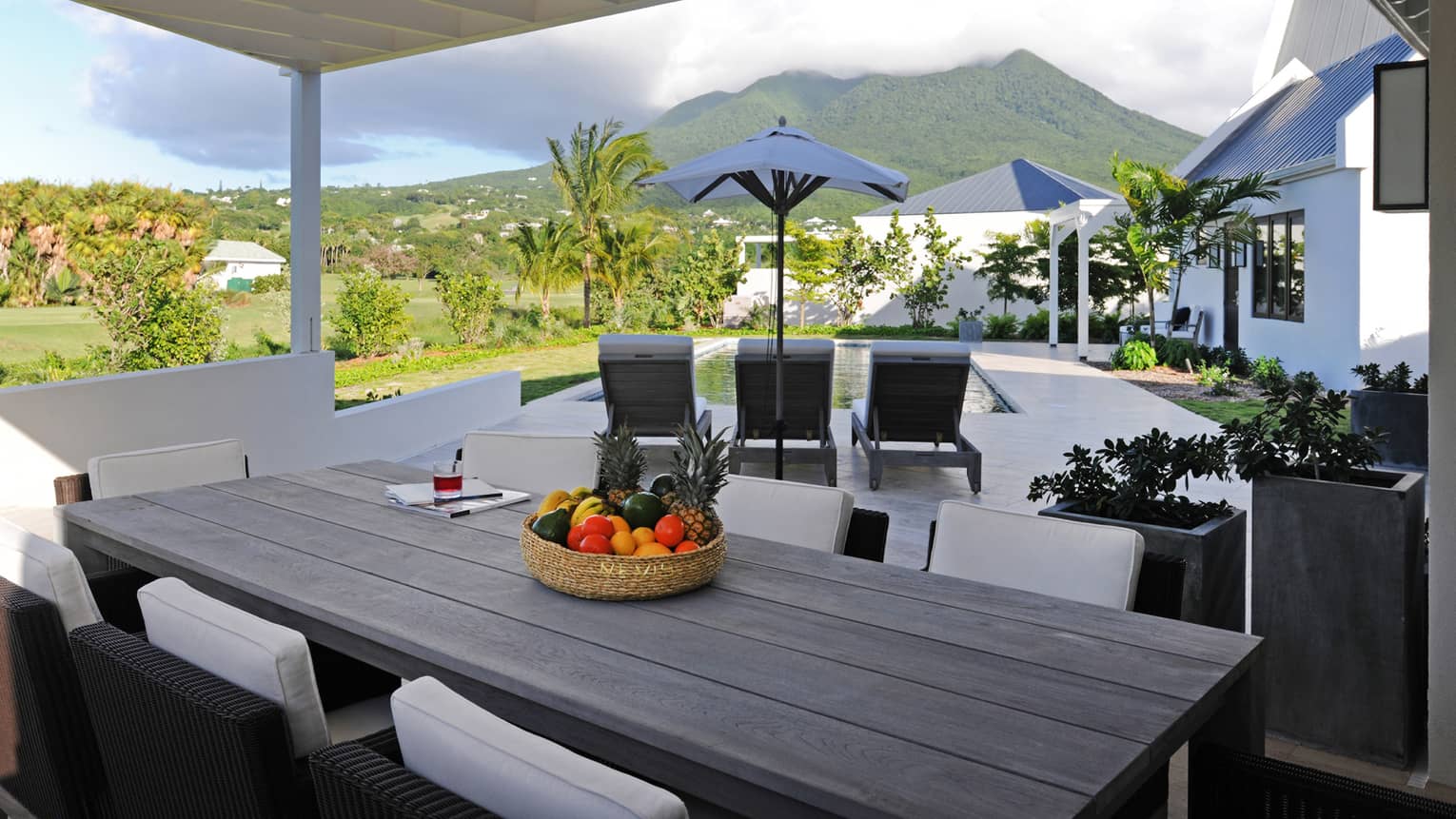 Pinney's Beach Residence Villa long patio dining table, wicker bowl with fruit