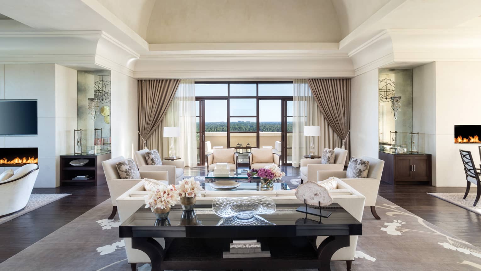 Large black console table with vases, fresh flowers in front of seating area with white sofas