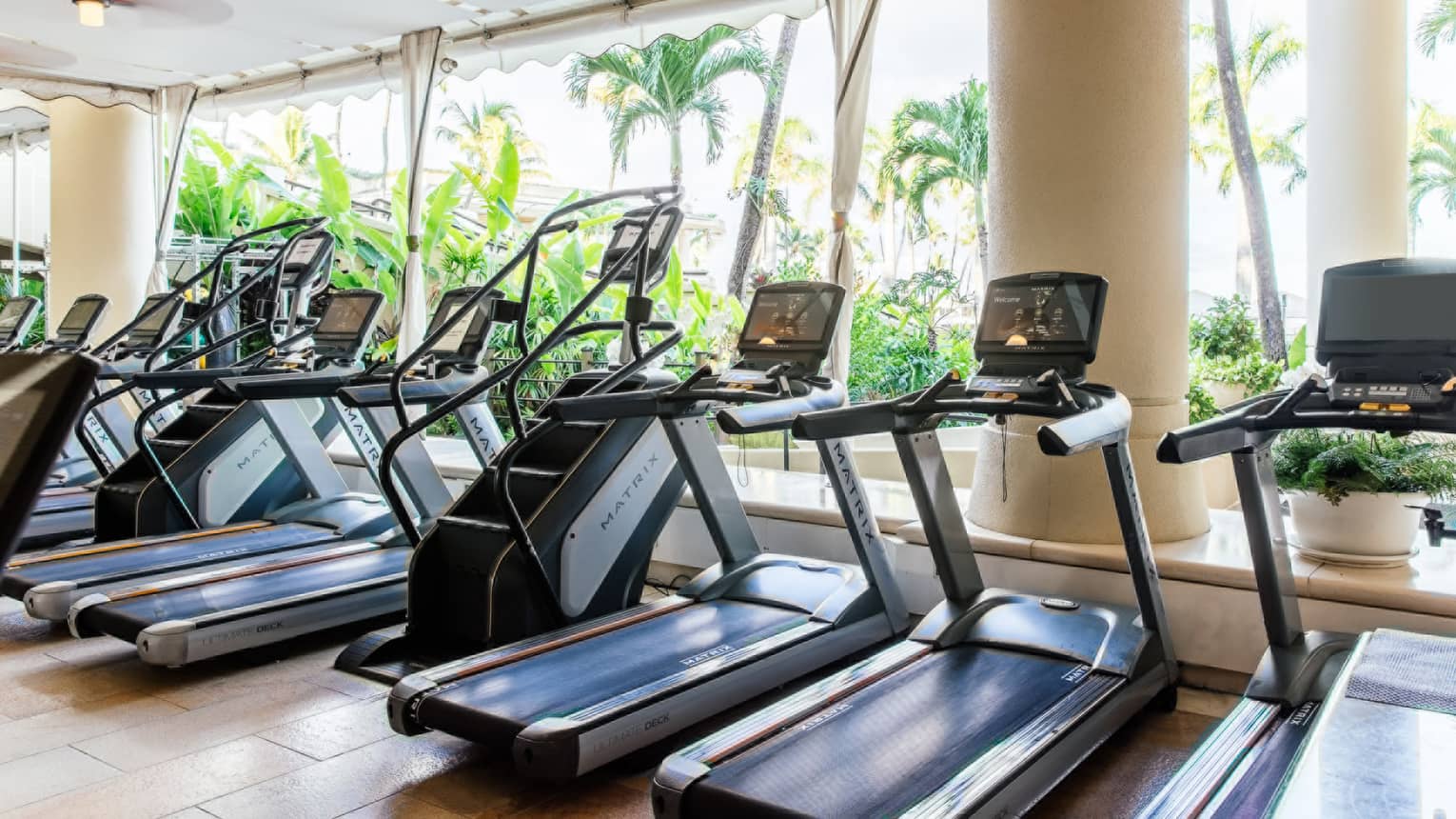 An open-air fitness center with treadmills and stair climber machines