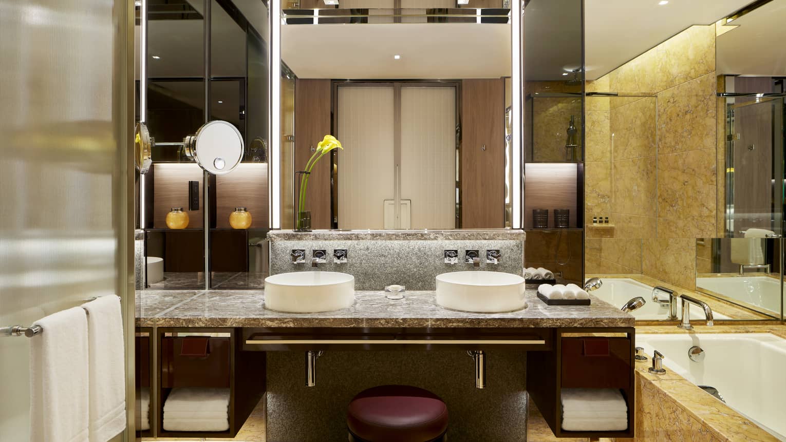 Bathroom with double vanity, tub, wall of mirrors