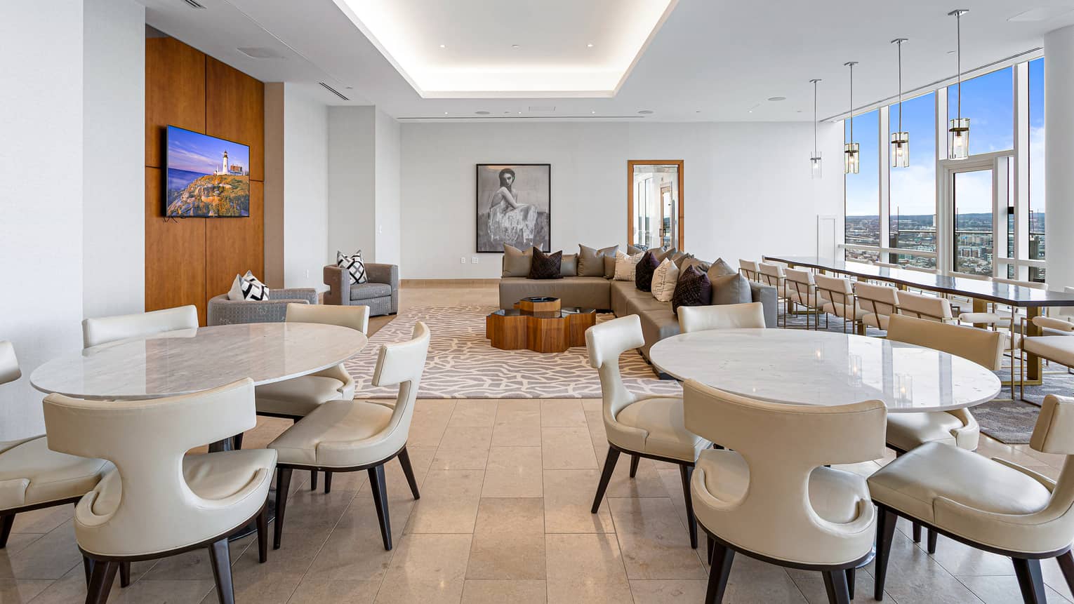 Lounge area with tables, chairs, bar seating and lounge area with TV