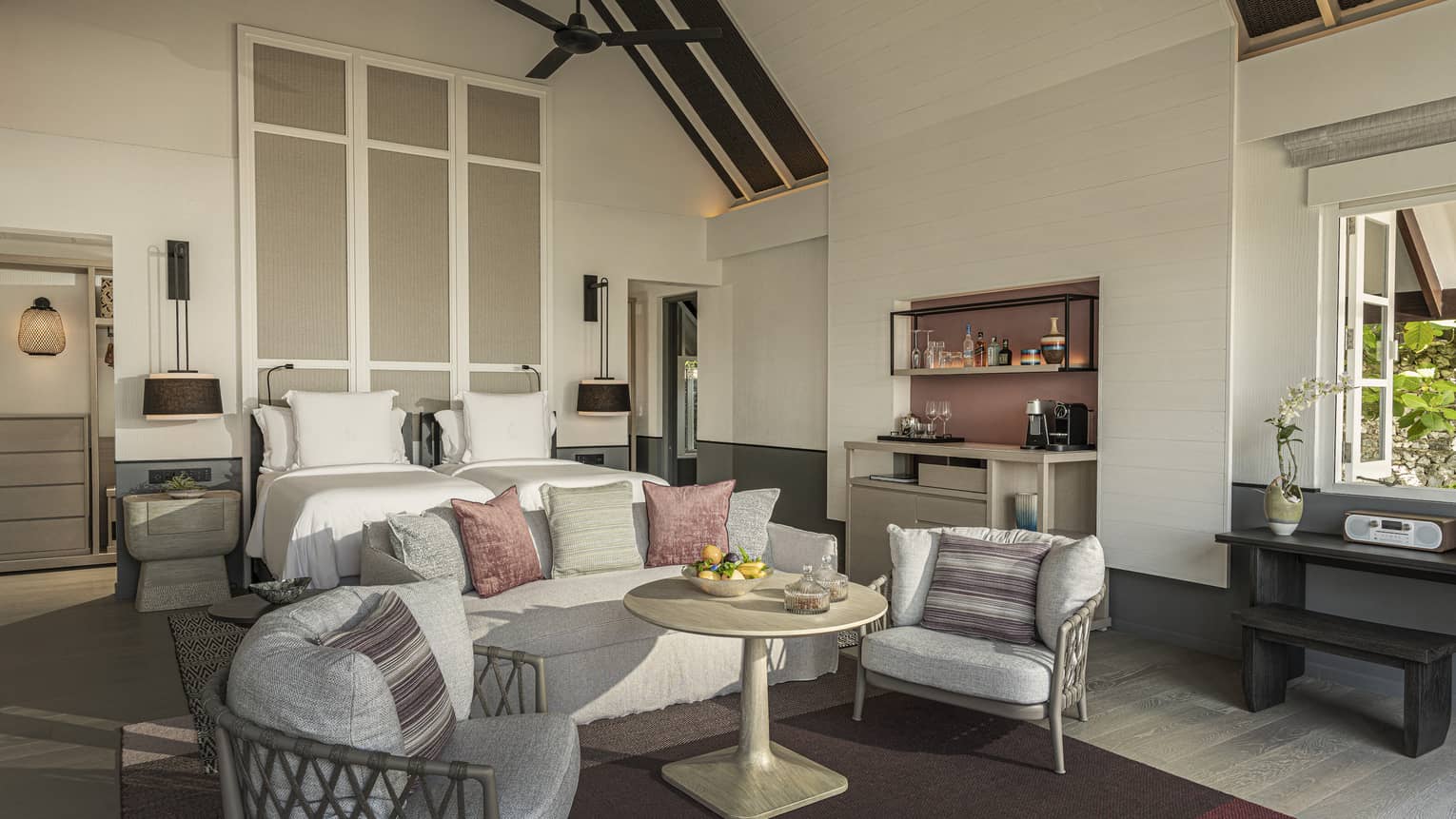 Bedroom with vaulted beamed ceiling, king bed, sofa and two chairs