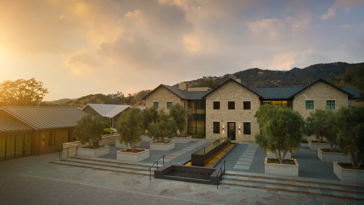 Thee exterior of a resort property during sunrise.