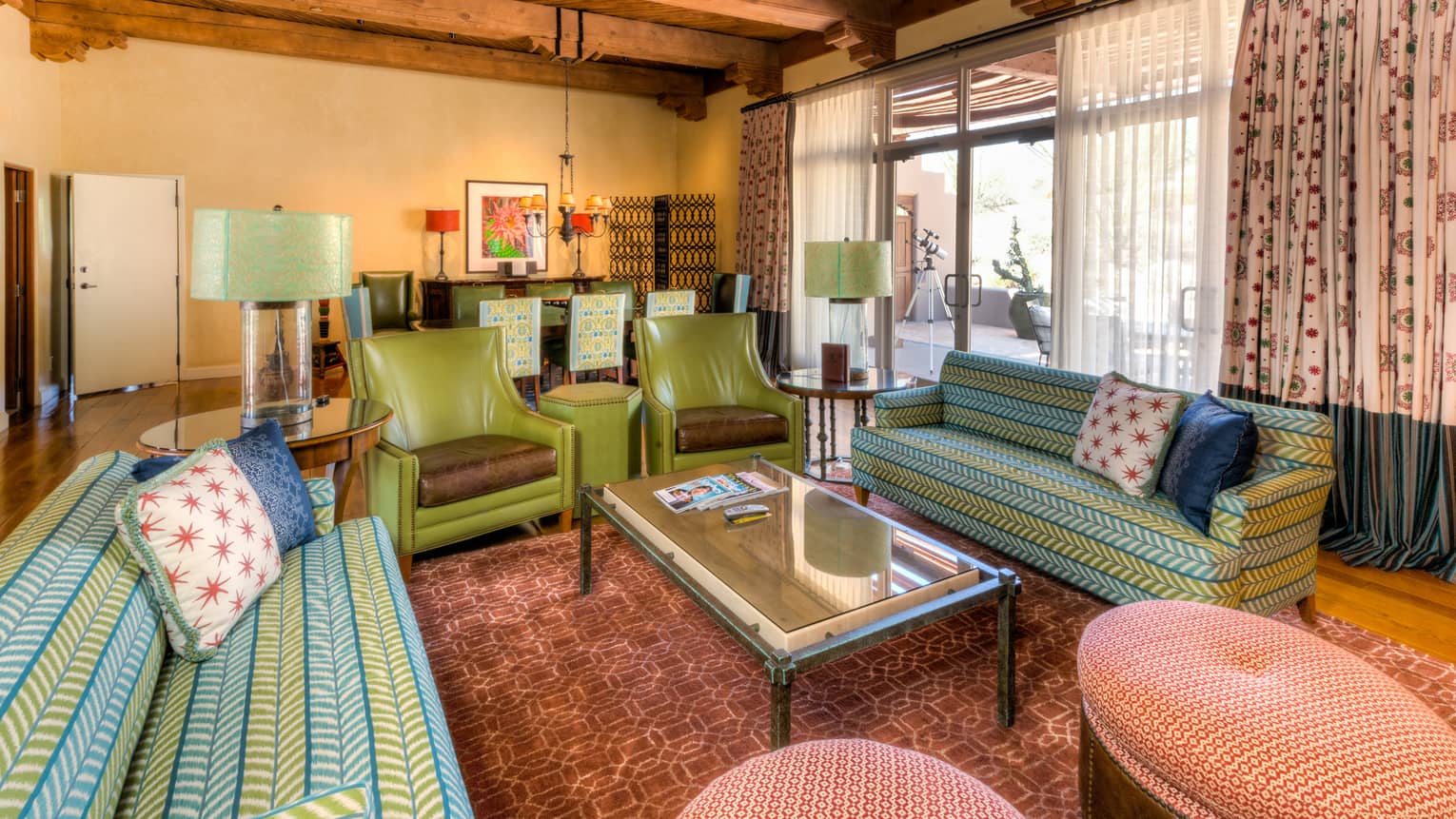 Pinnacle Three-Bedroom Suite with blue-and-green sofas, armchairs, coffee table, floor-to-ceiling windows