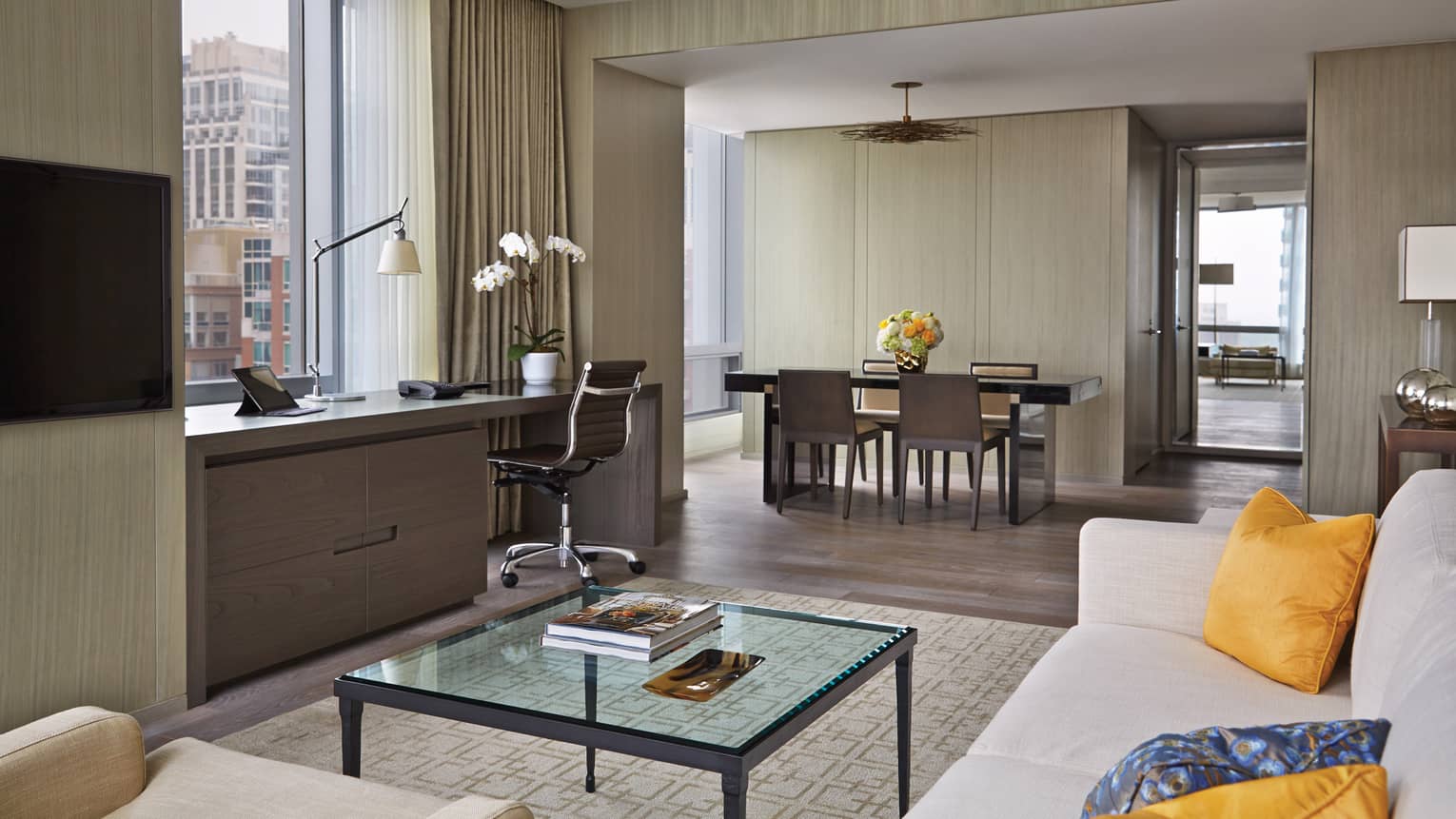 Yorkville Suite living room, glass table, desk under window, dining room by bedroom door
