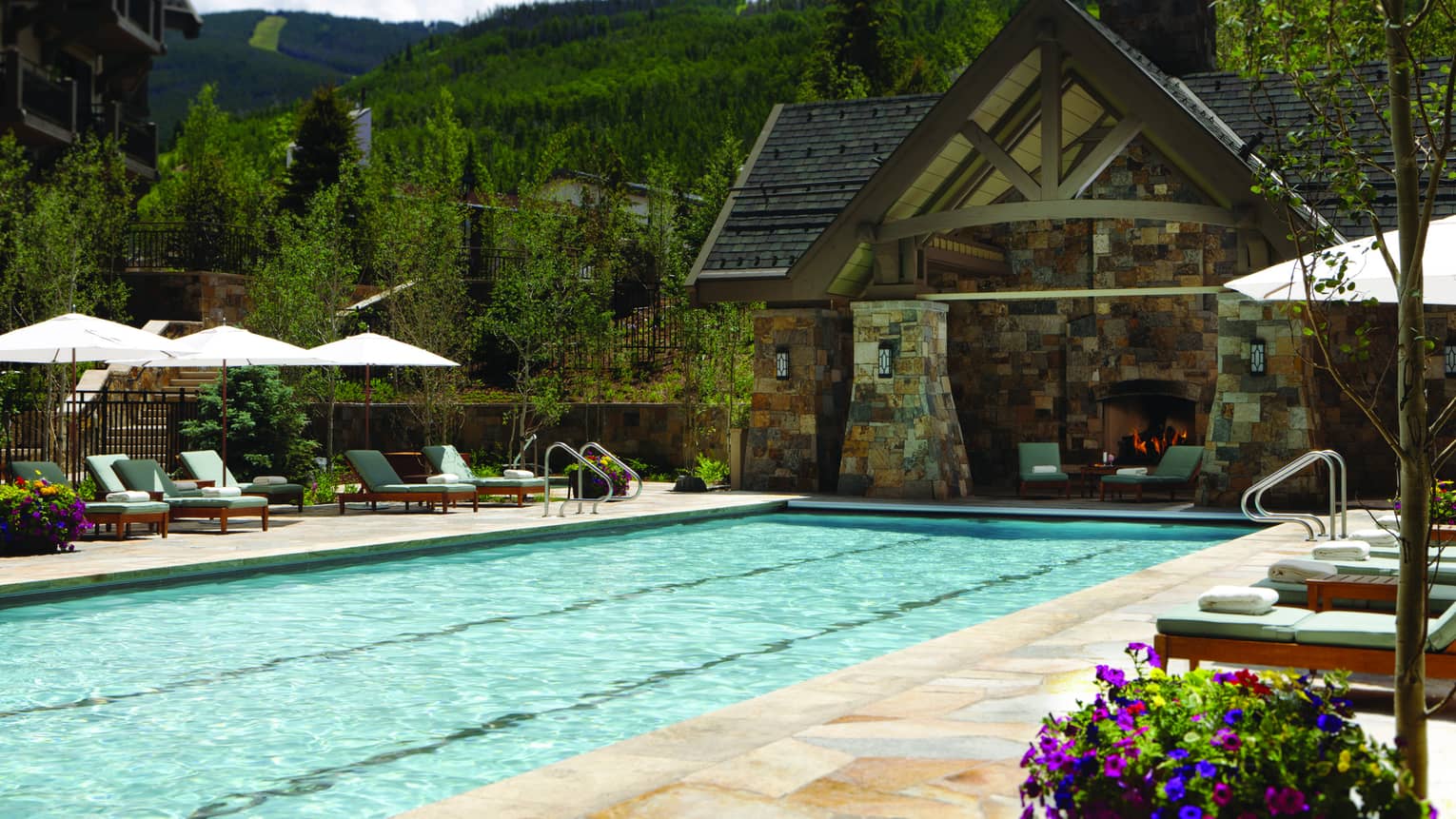 Outdoor lap pool at Four Seasons Resort Vail, lined with lounge chairs