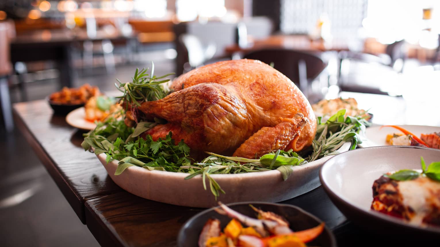 A roasted turkey on a large tray in a restaurant.