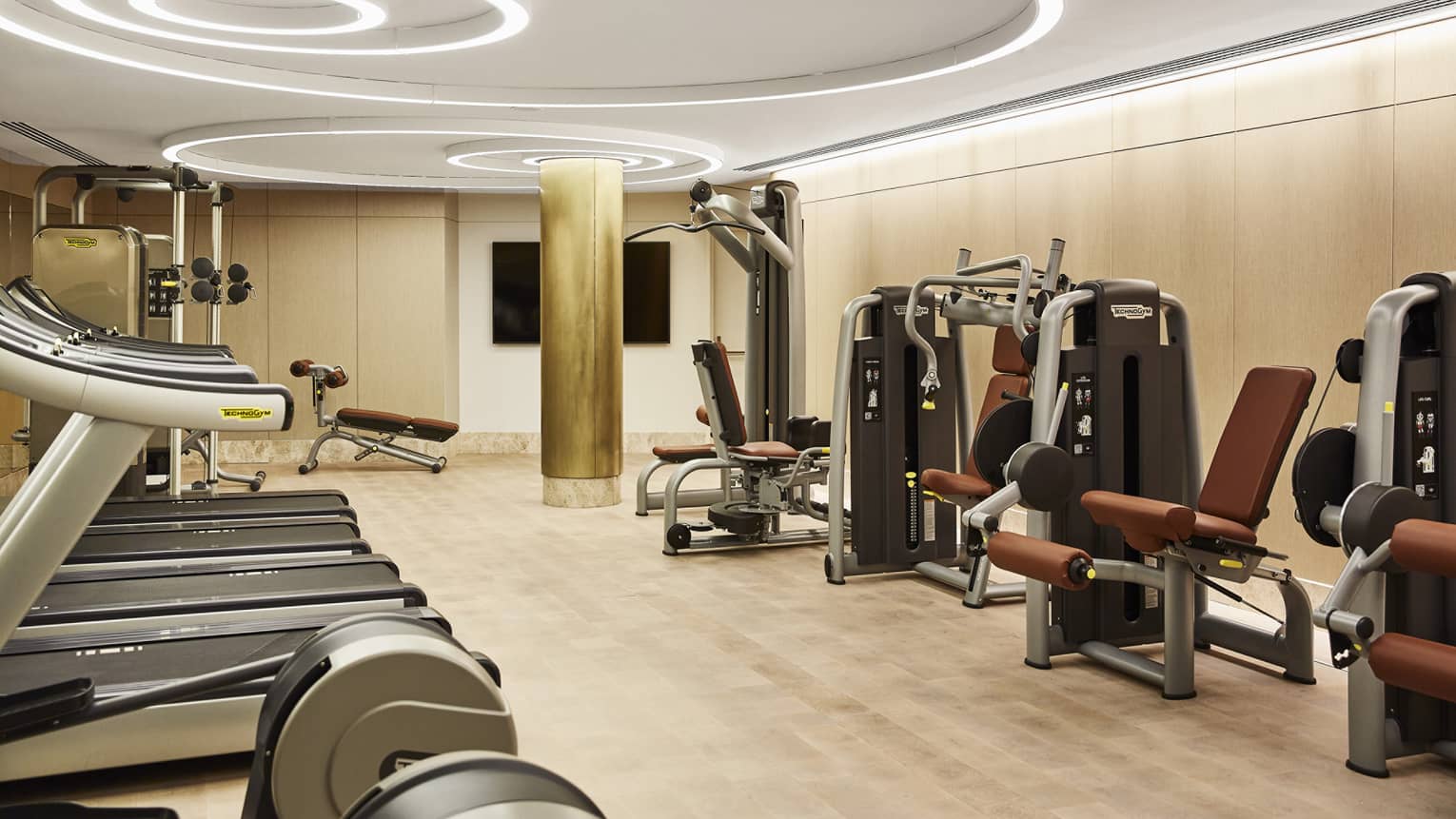 Fitness centre with three treadmills, weight-training machines, modern circular lights on the ceiling