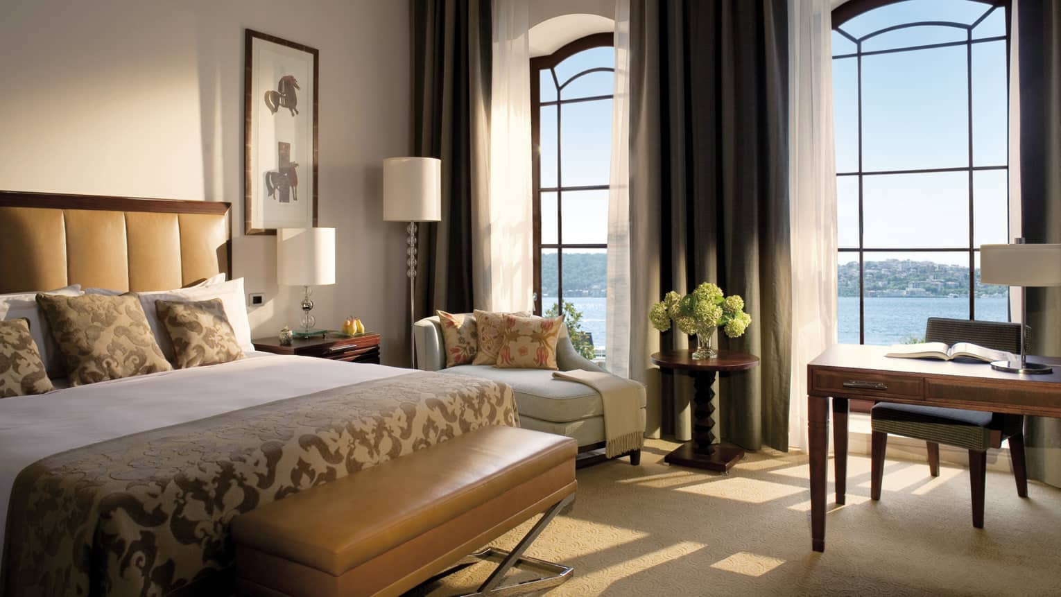 The Palace Bosphorus Room bed with padded brown headboard, bench, sunny bay windows with sea views
