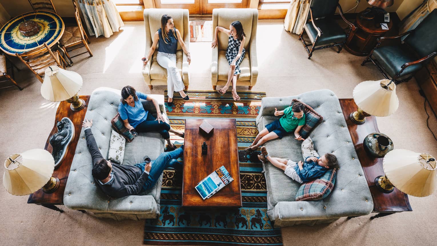 Aerial view of guests talking and relaxing in the living room of a residence 