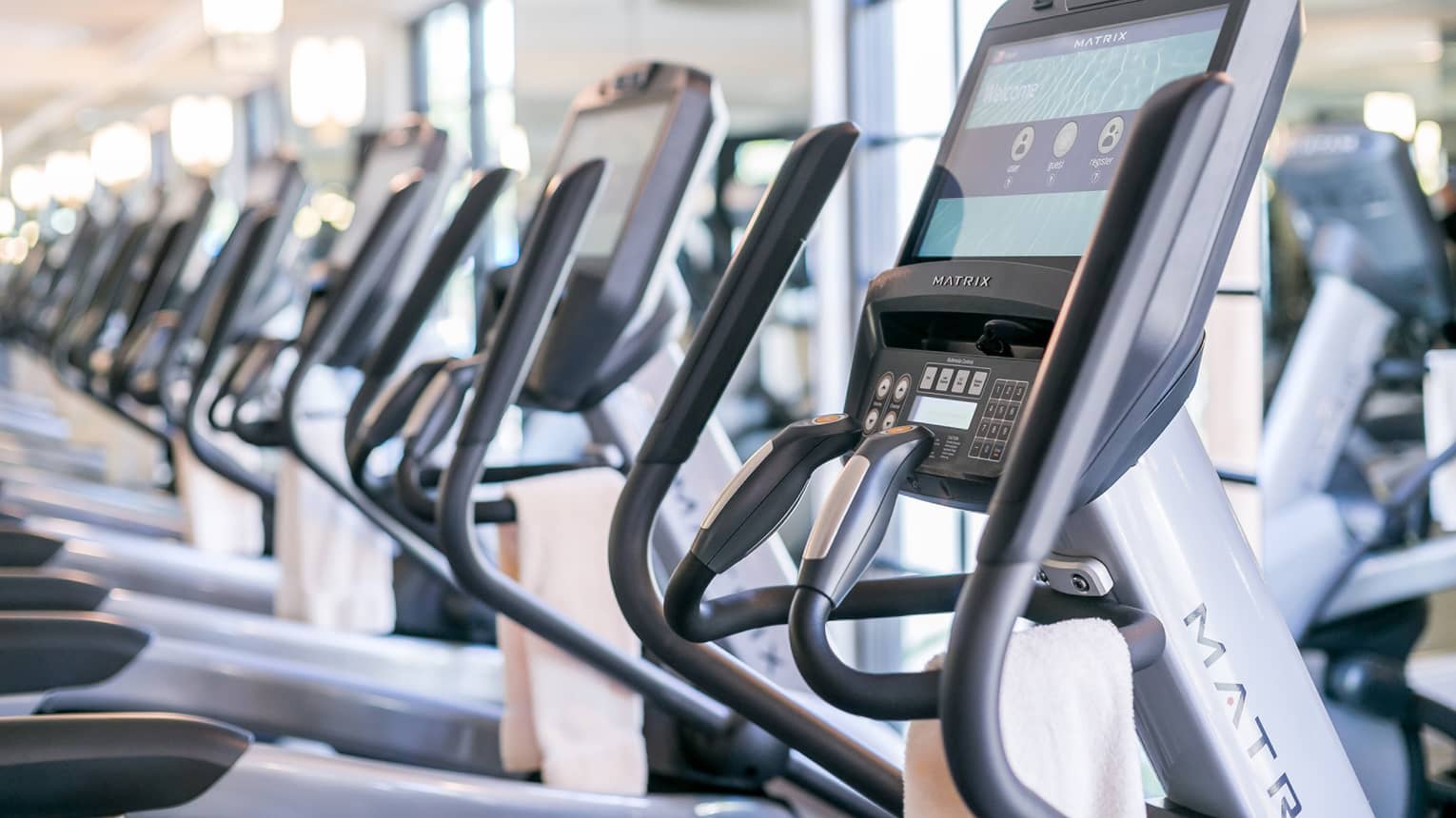 Close-up of cardio elliptical machines in a row in fitness facility