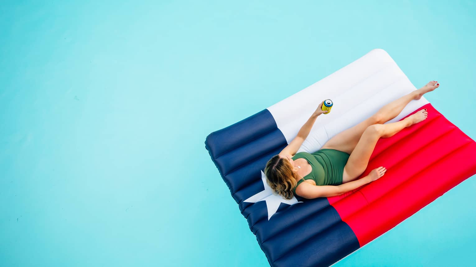 a woman lounges in a pool on a float that looks like the texas state flag