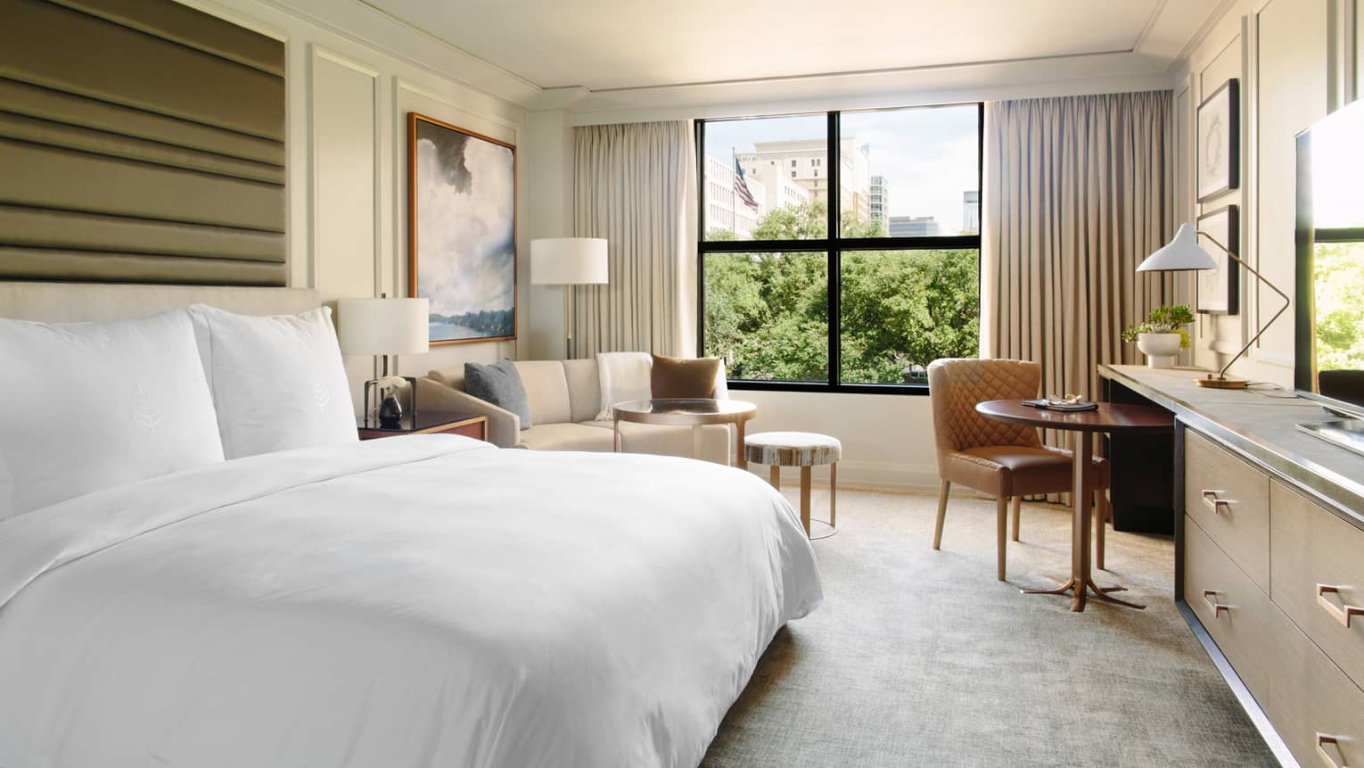 City-View Room bed, framed painting over sofa, tables by window