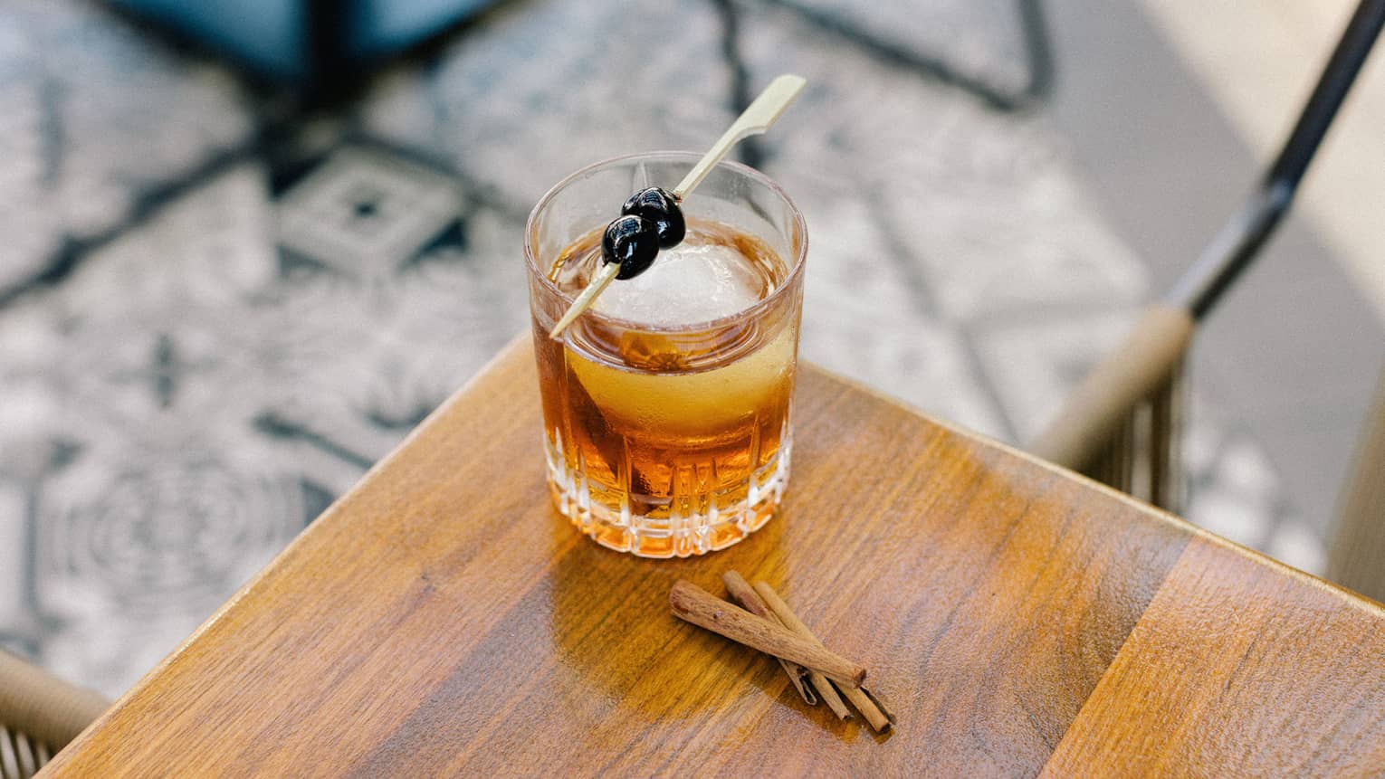 A cocktail with blueberries as a garnish.