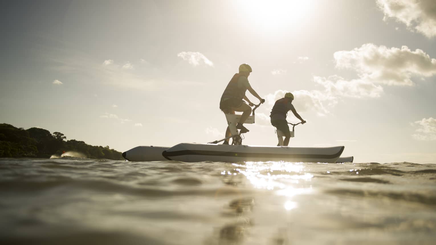 A couple of guests go water biking on the river in Bali