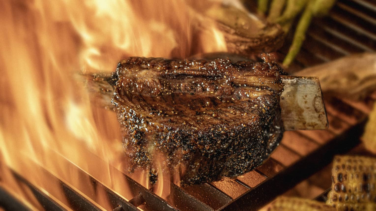 Close-up of chargrilled steak, asparagus and corn on grill grates