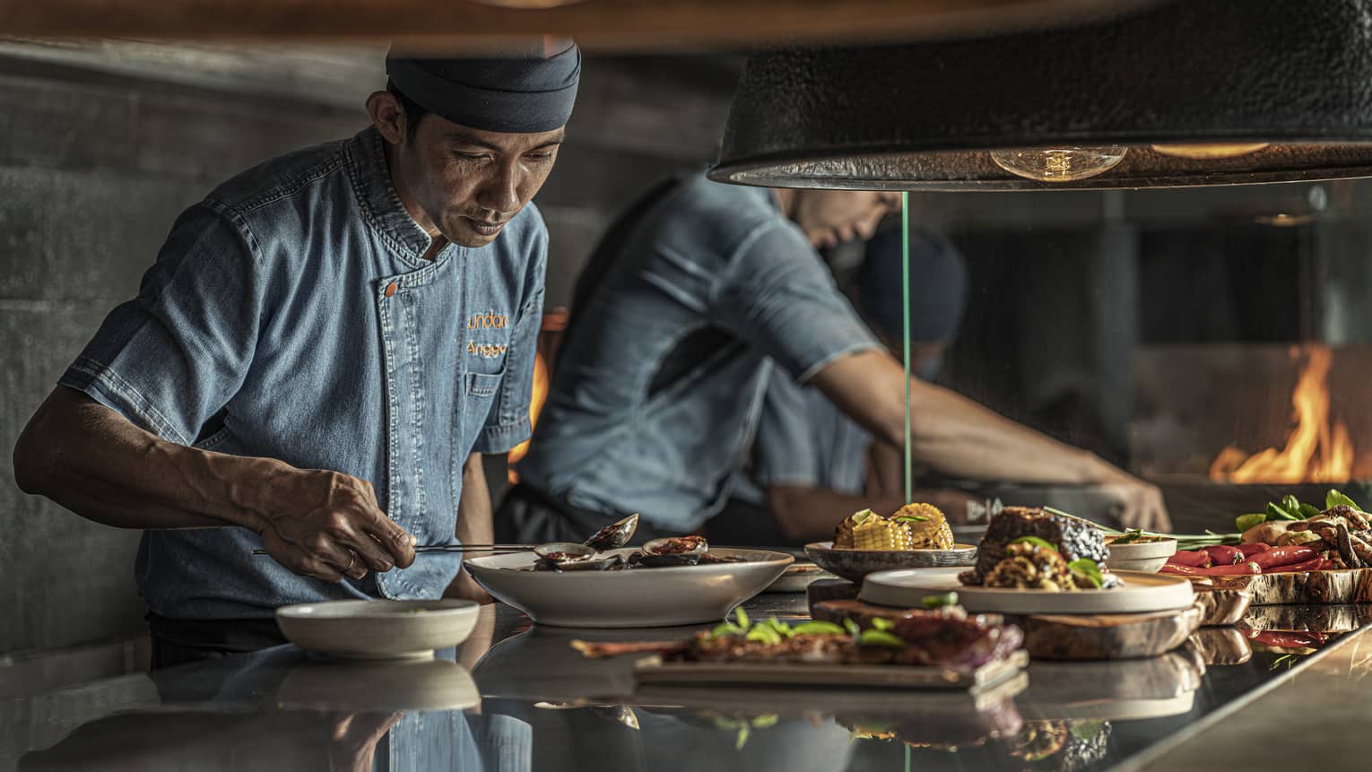 Two chefs put finishing touches on dishes at Sundara