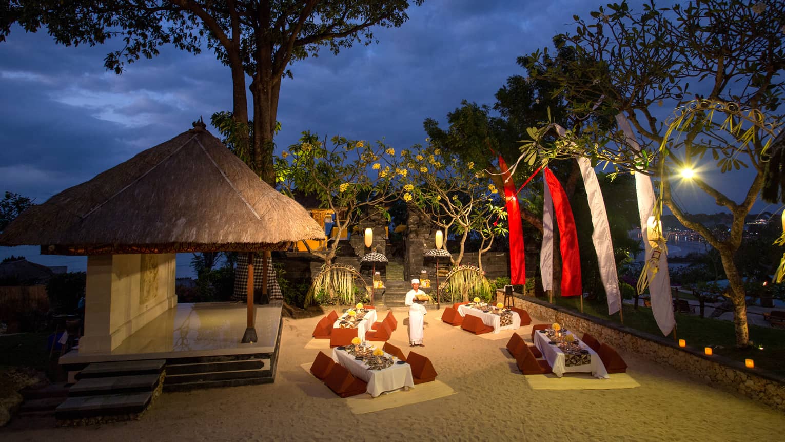 Megibung themed dinner at temple courtyard at night, with cushions around communal tables 