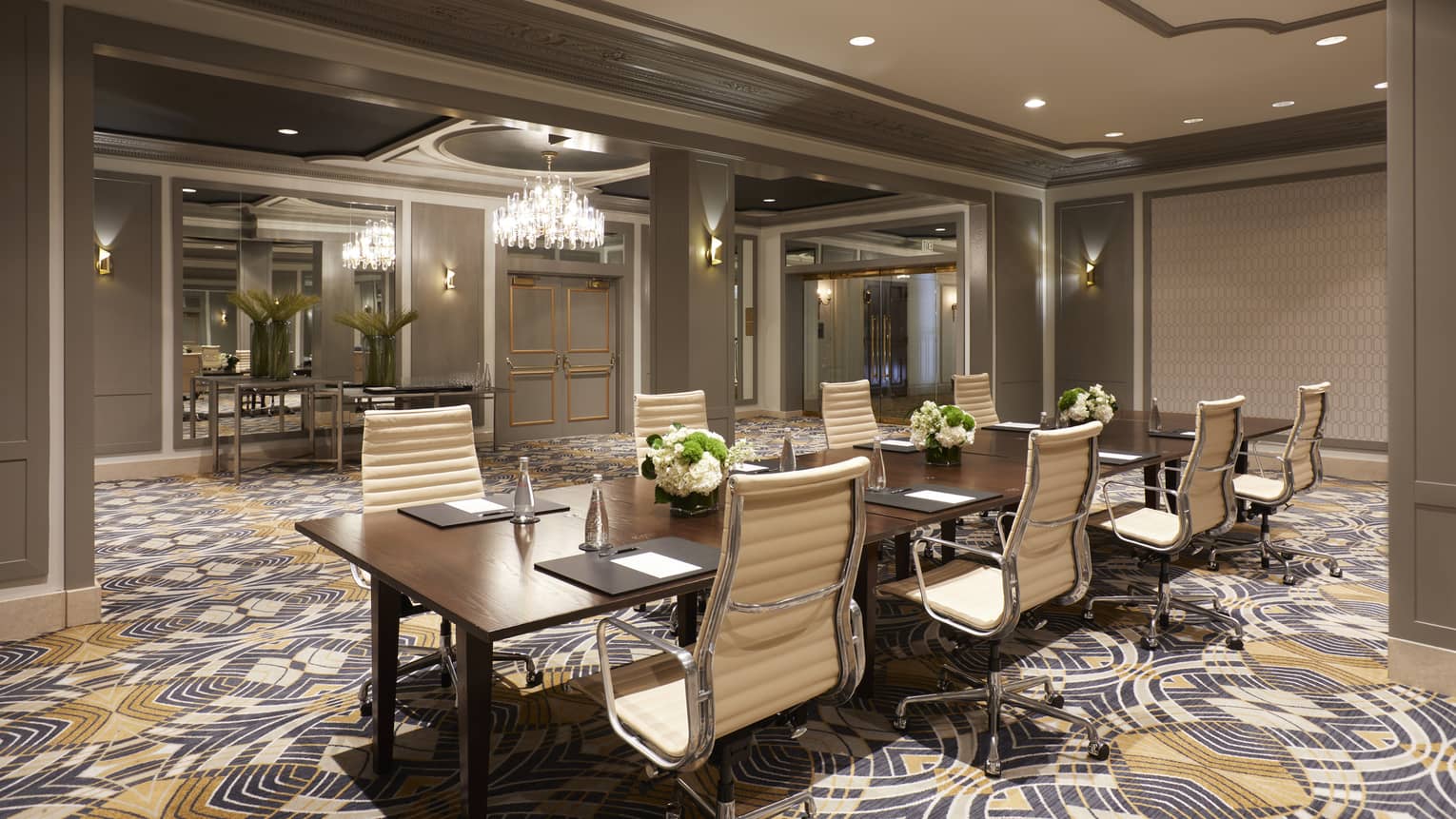 Meeting room with colourful patterned carpet set up with a conference table and eight chairs