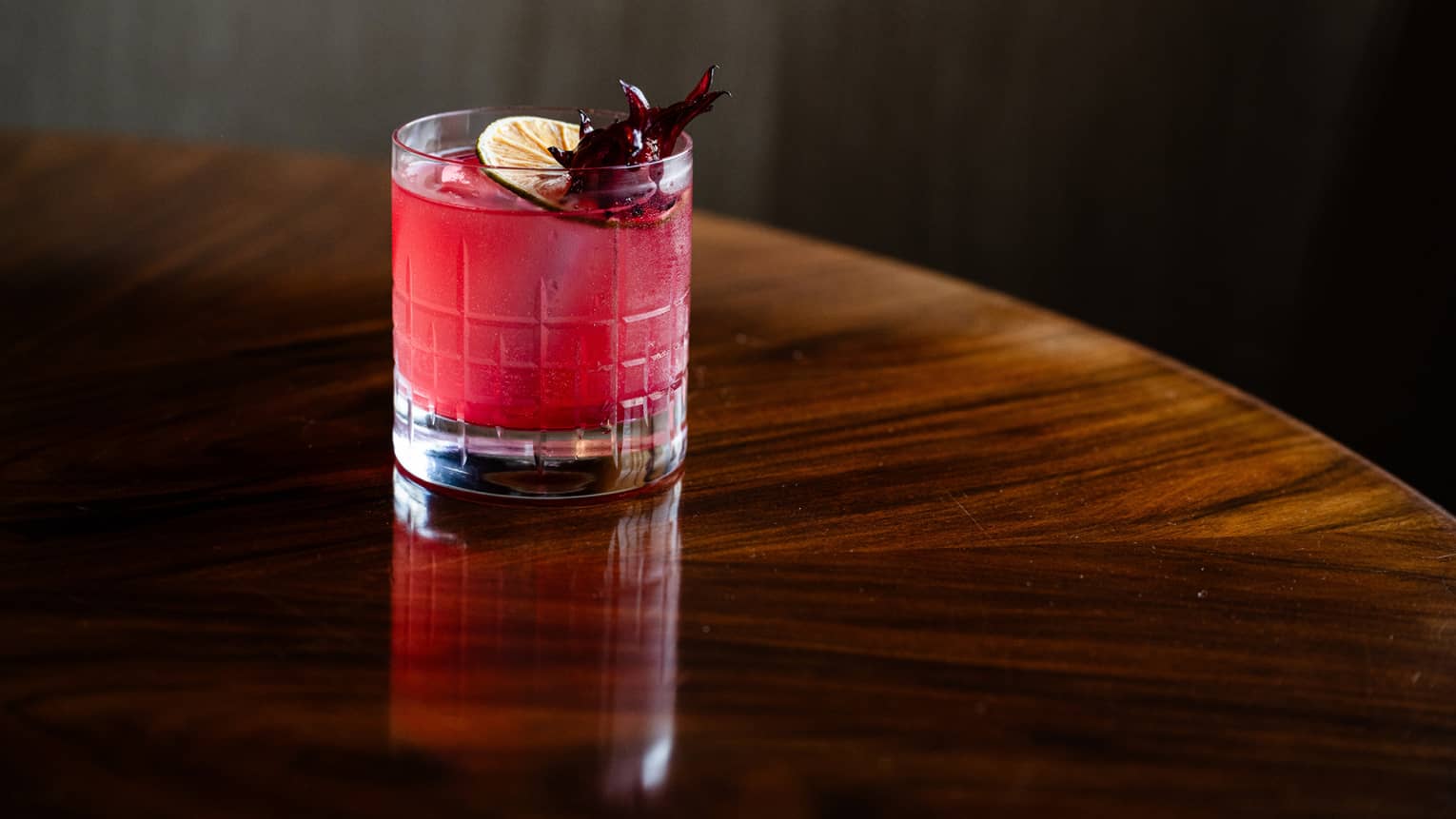 Pink drink with slice of lemon on top.