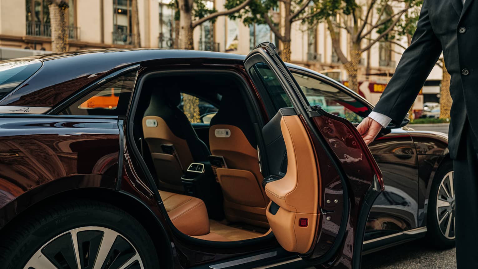 Person wearing a suit and opening a car door