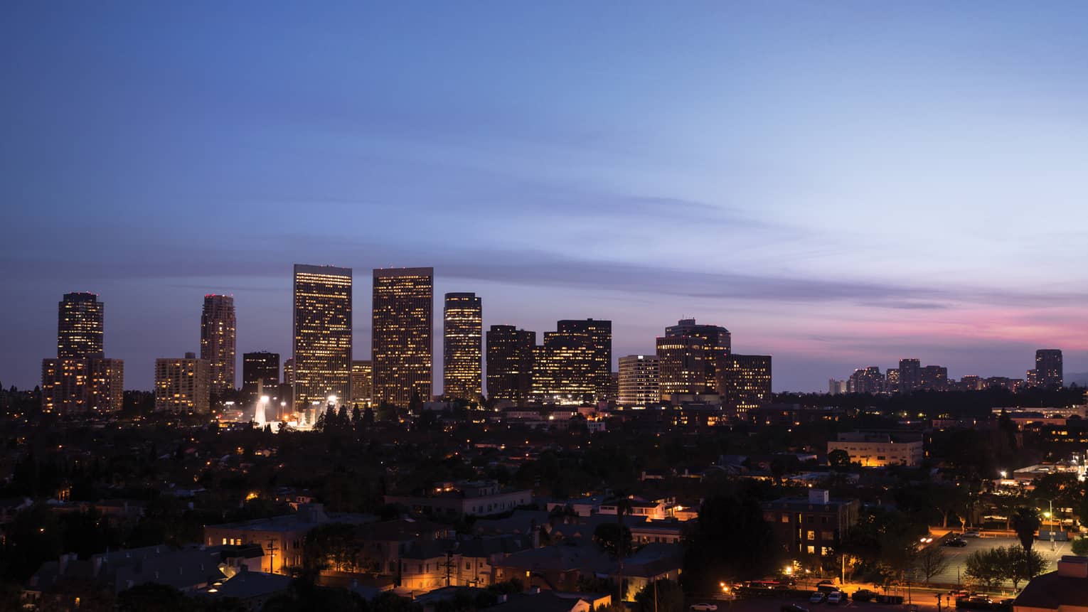 View of the city skyline with a purple and pink sunset.
