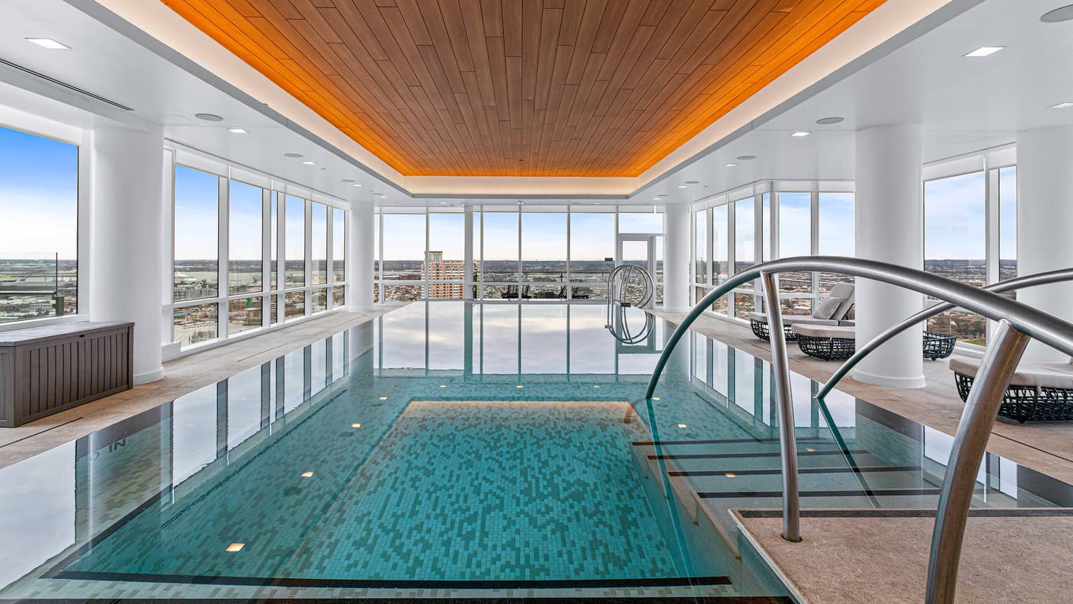 Indoor pool with floor-to-ceiling windows, bathed in natural light