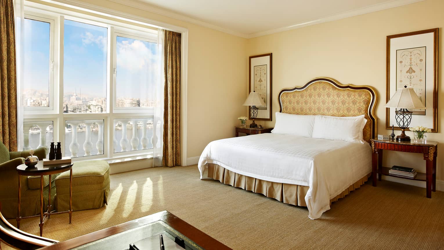 Premier Room bed with gold pattern upholstered headboard, cream-coloured walls, chaise by sunny window