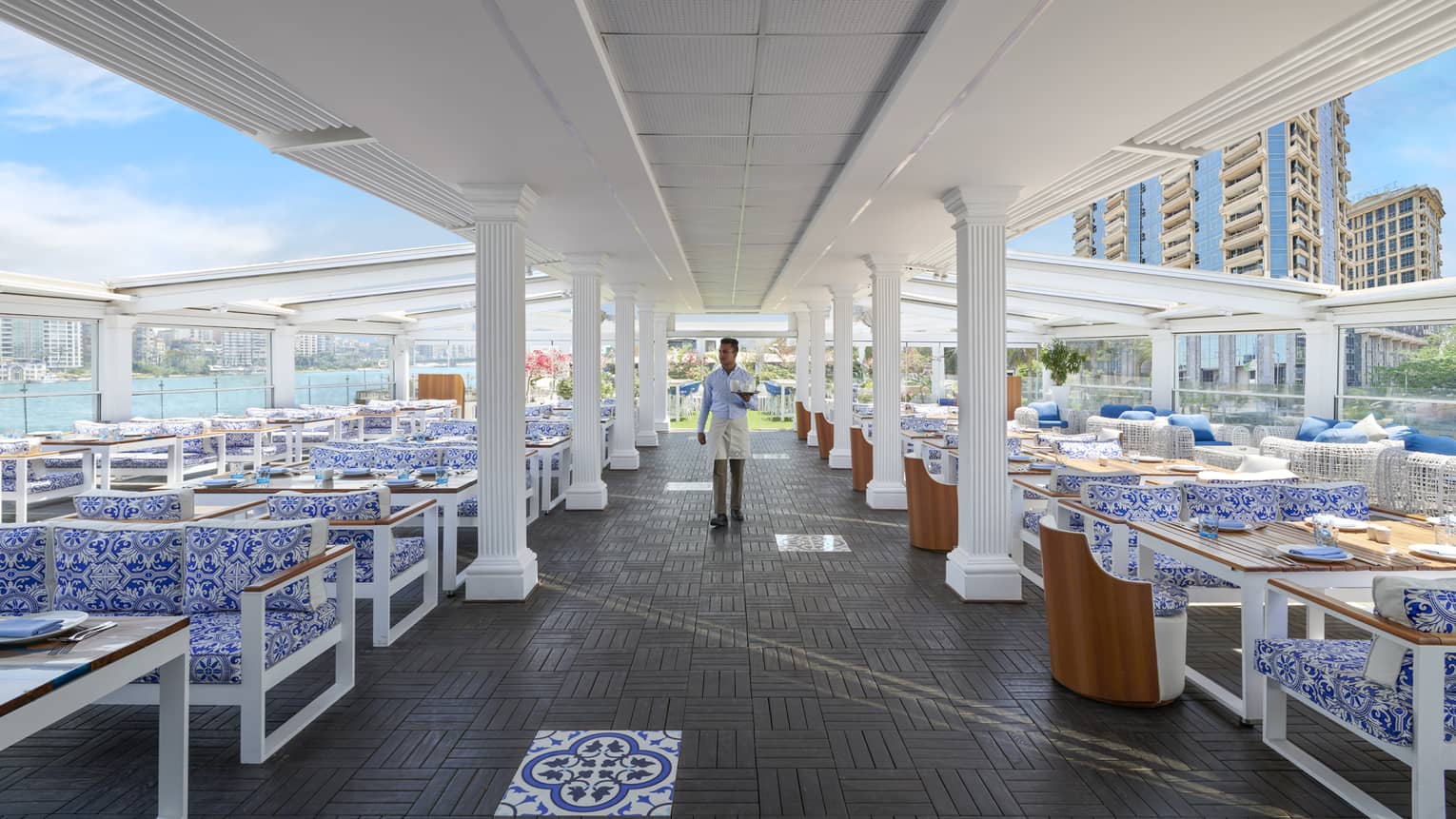 Waiter walks down the aisle of seats at open-air Zoe