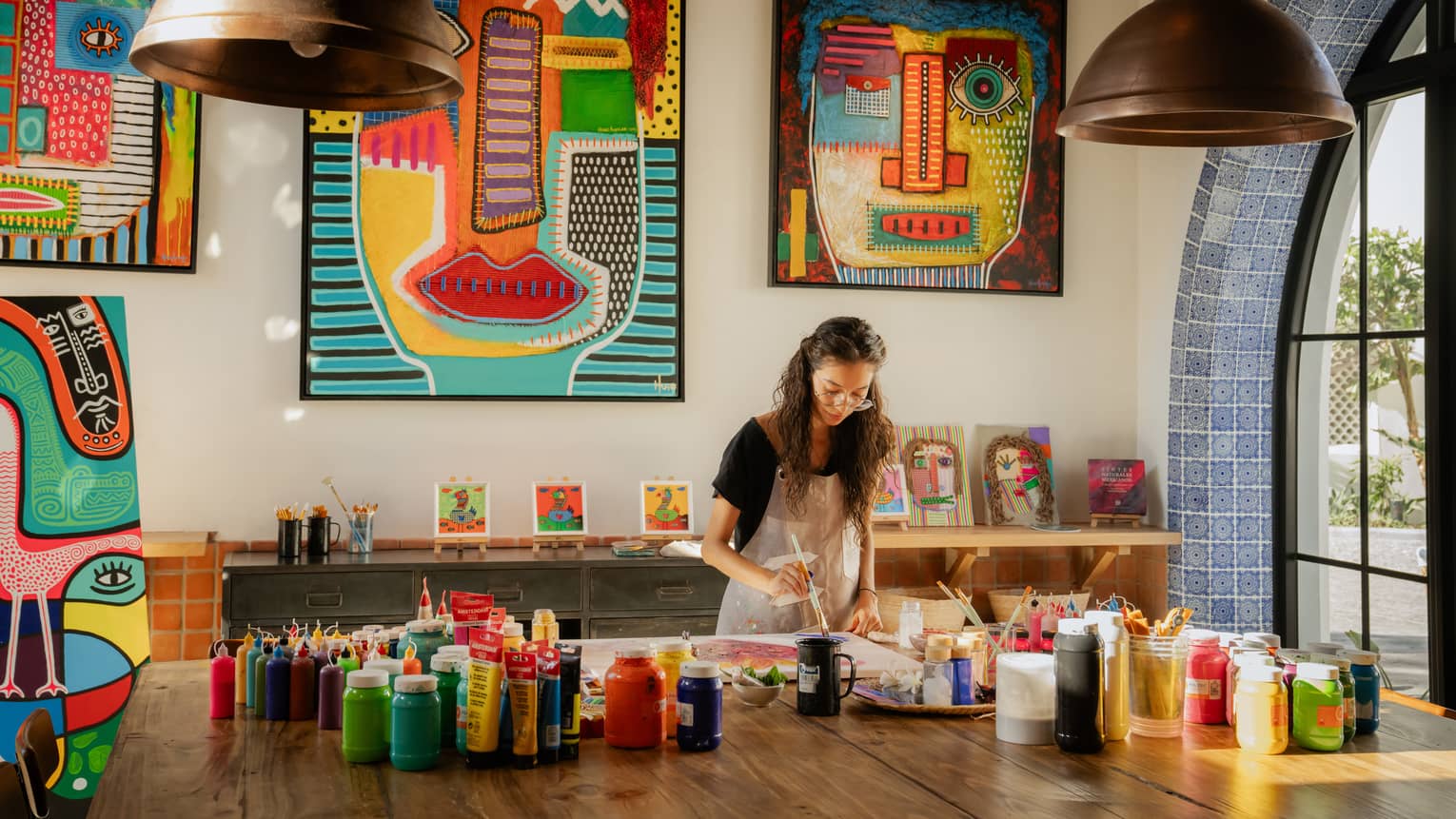 Woman paints in colourful art studio at luxury resort