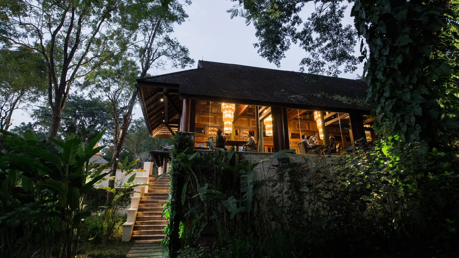 Wood steps leading up to KHAO restaurant at dusk, diners visible in window