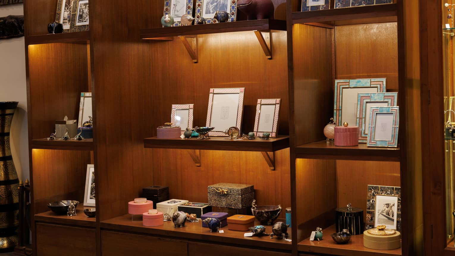 Retail items displayed on a lighted wall of wood shelves