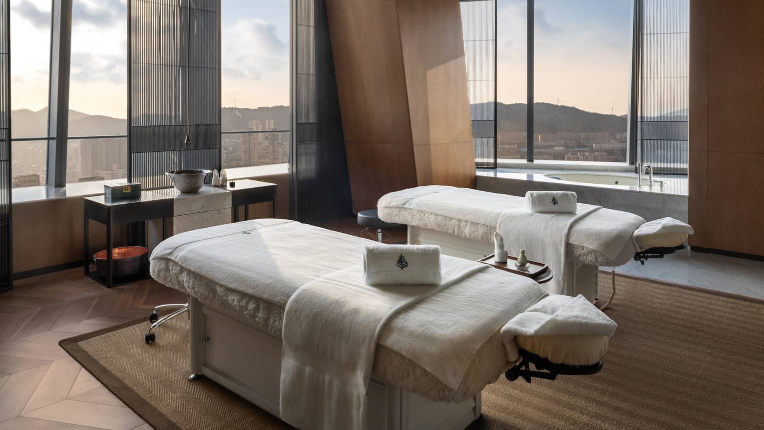 Spa treatment room with two treatment beds and expansive views of Dalian, China