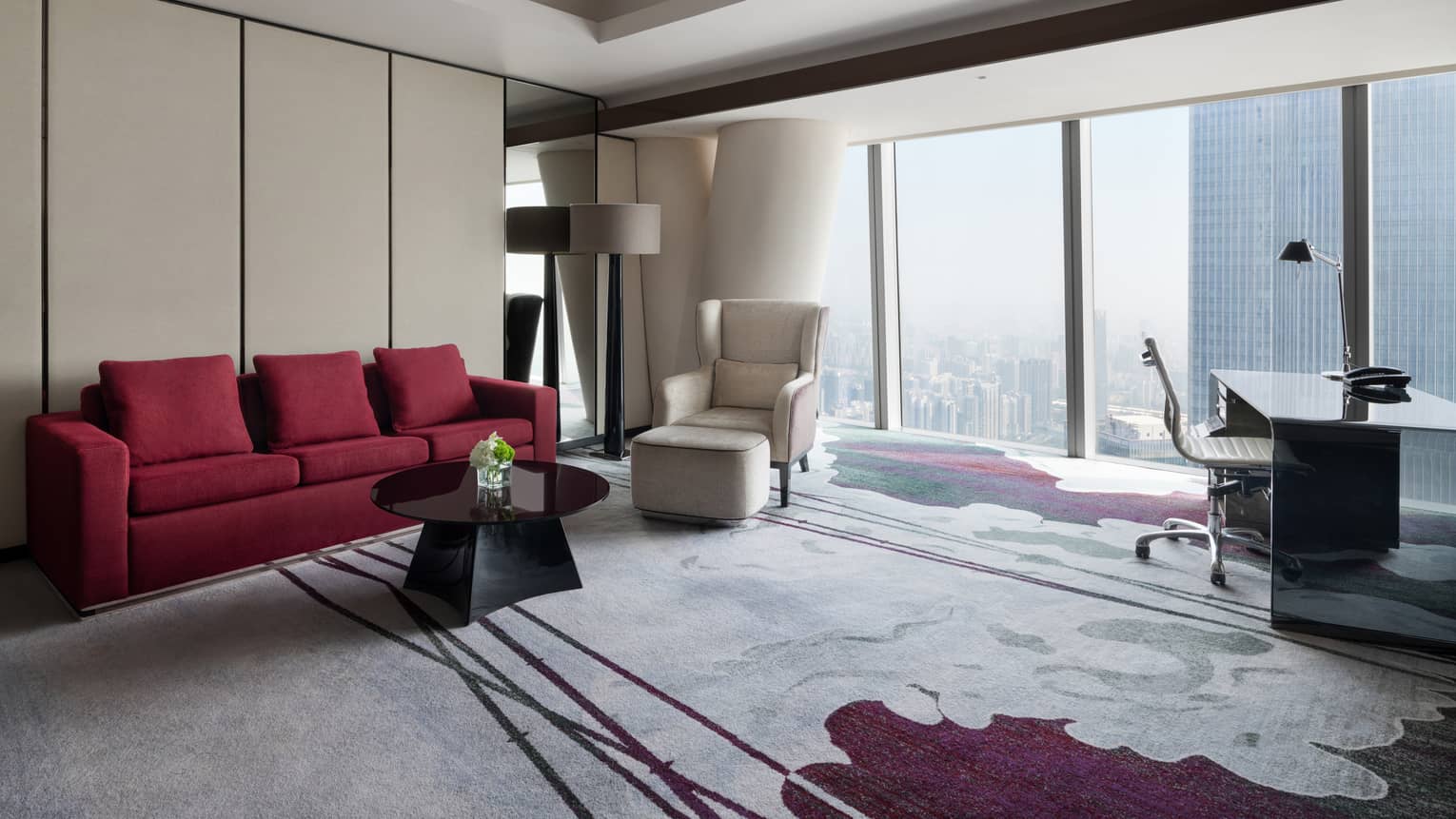 Deluxe King River View Suite living area with red sofa and floor-to-ceiling windows
