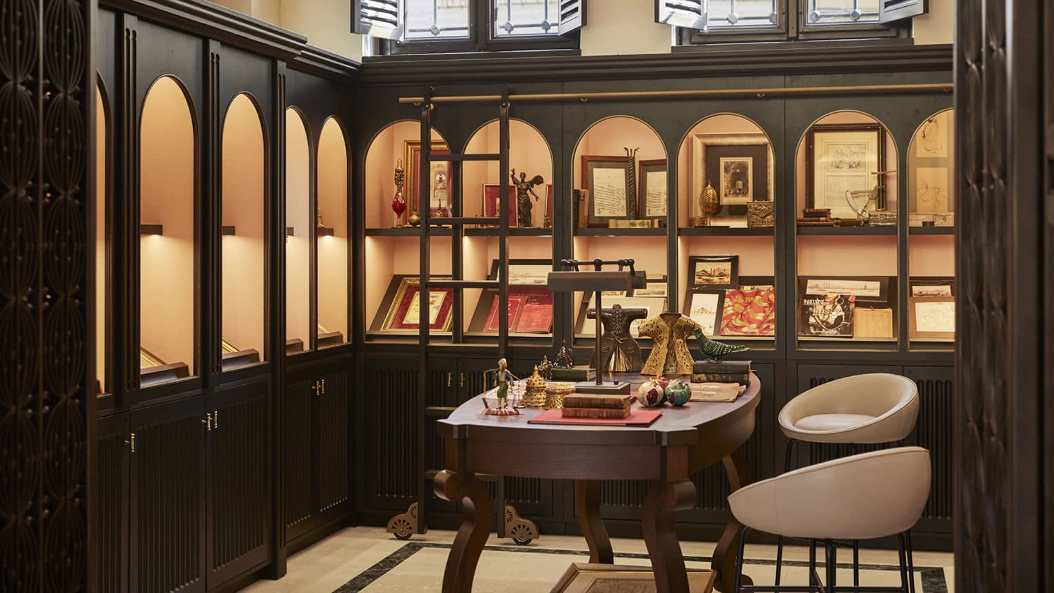 A store with items and books on shelves and a small table with chairs.