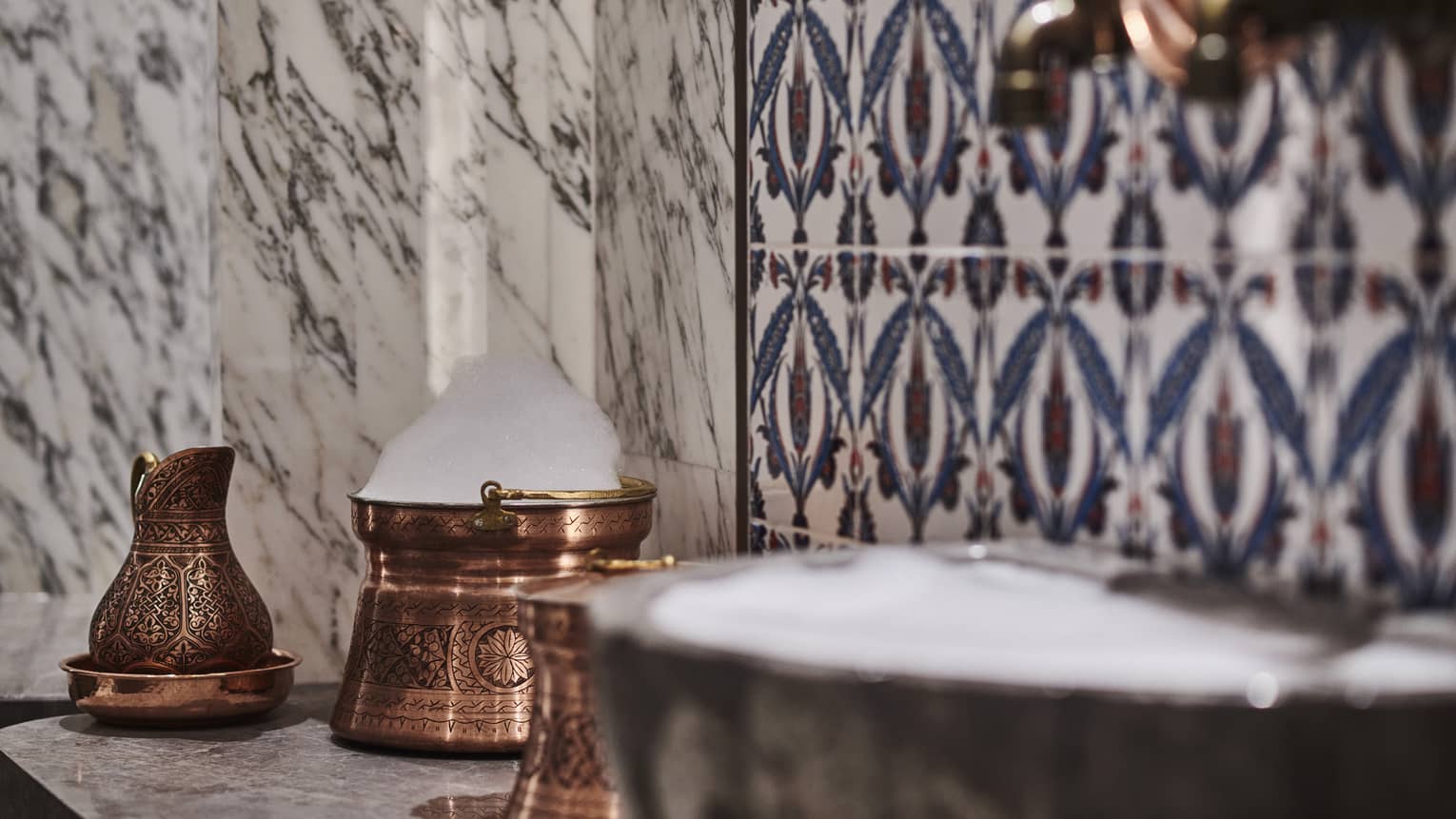 Kuma Spa tiles and marble walls by copper sink